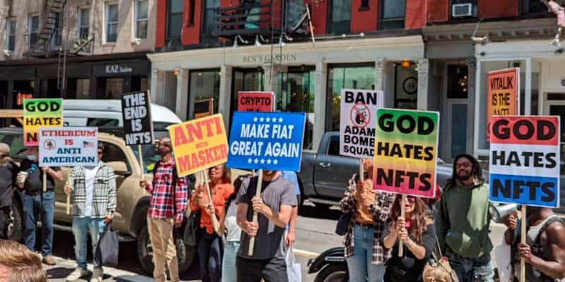 Protesto anti Anti-NFT: evento NFT.NYC com cartazes, "Deus odeia NFT"